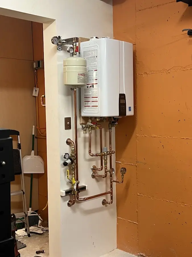 Plumbing technician inspecting water heater connections in Northwoods